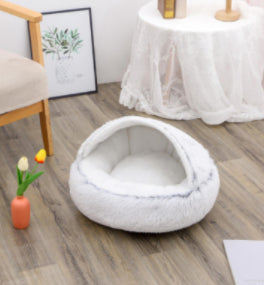 Round white plush pet bed with thick cushioned rim and open center for pets