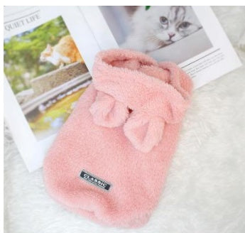 Pink plush cat outfit pouch with gathered hood and bow; small logo patch on front