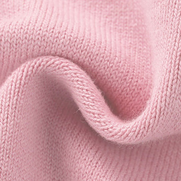 Pink knit pet sweater fabric close-up with textured ribbing and stitched hem
