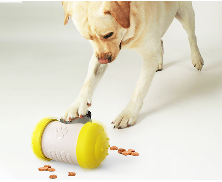 Treat-dispensing wheel toy with yellow end cap, white body, and scattered kibble