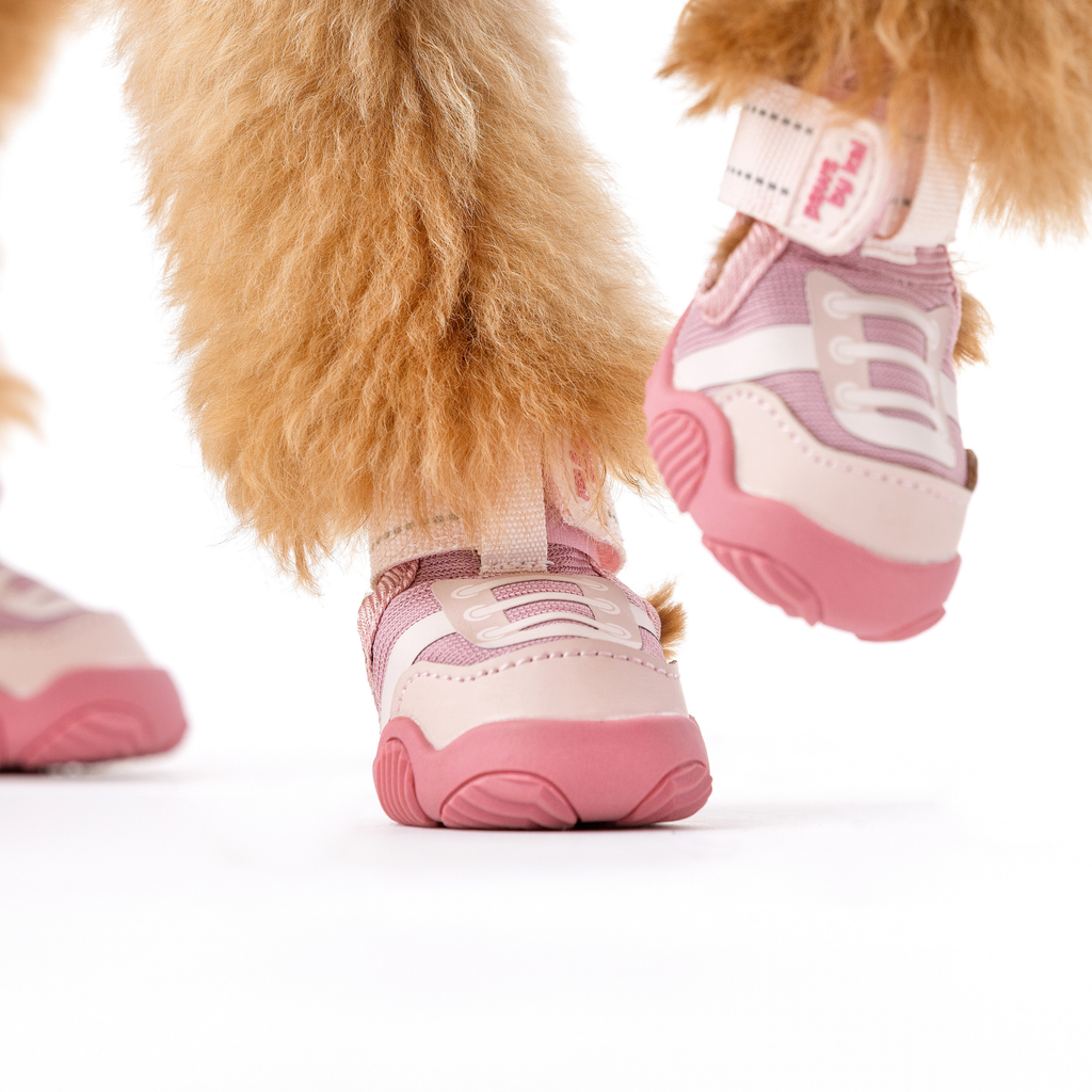 Pink dog sneakers with cushioned soles, front and side view on a dog