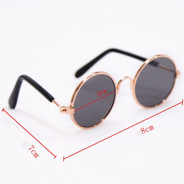 Round dark gray-tinted sunglasses with black temples and rose-gold frame