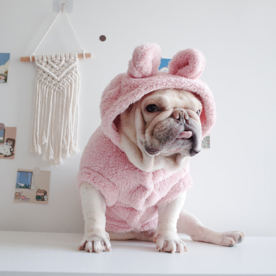 Pink plush pet hooded vest with hood and cartoon face, worn by a small dog