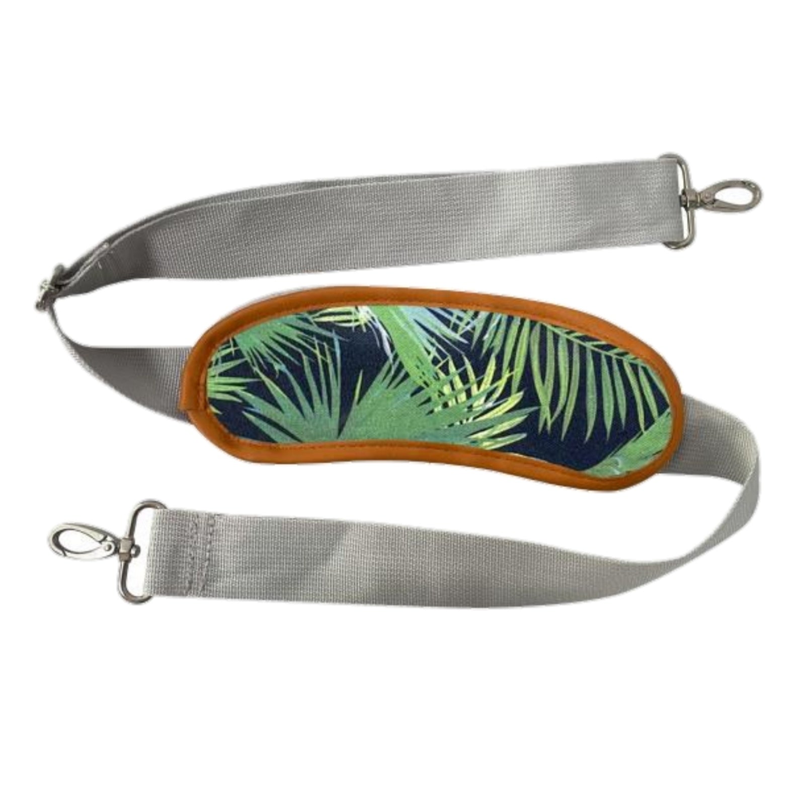 Adjustable shoulder strap with tropical palm-print trim for pet carrier.