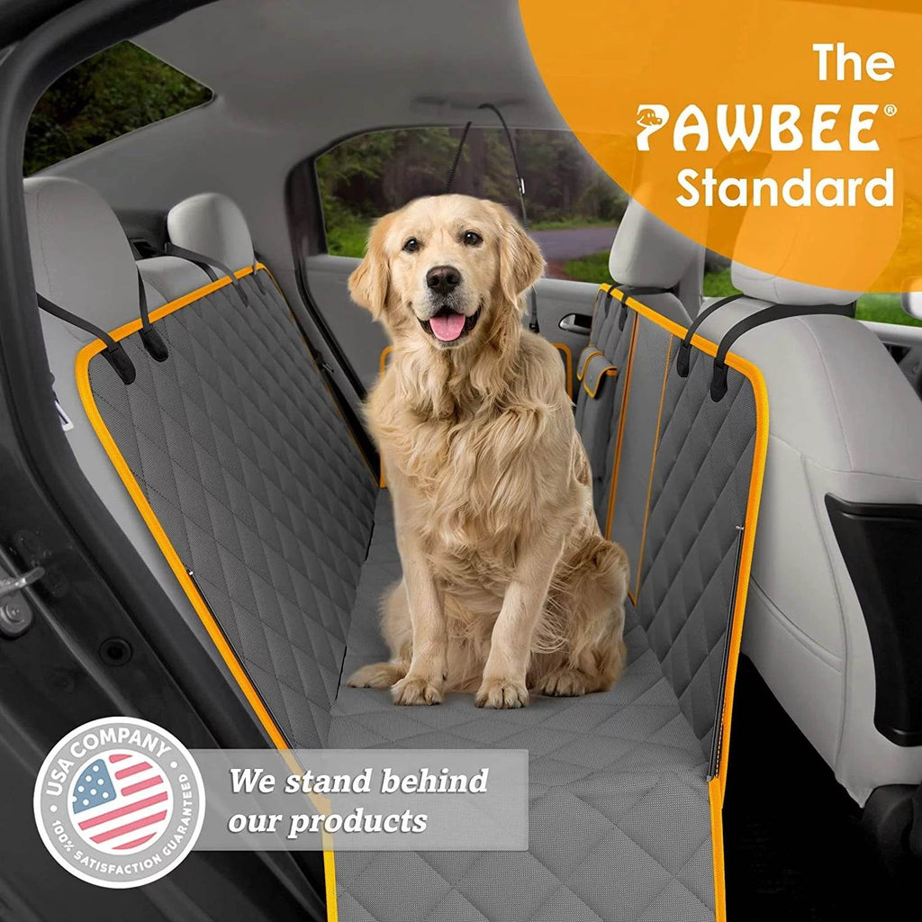 Golden retriever sitting on dark gray dog car seat hammock cover with orange straps