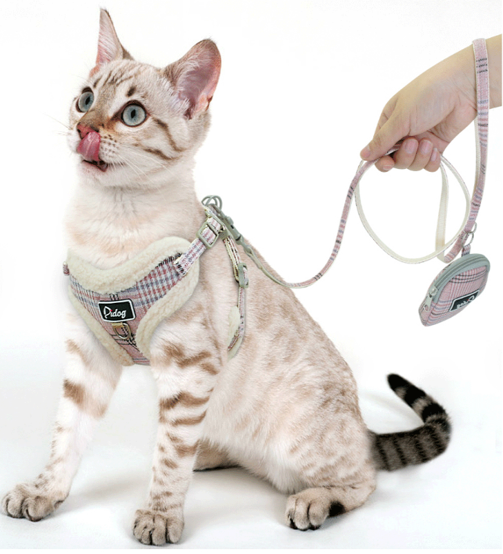 Plaid dog harness and leash set with adjustable straps and small round pouch accessory.