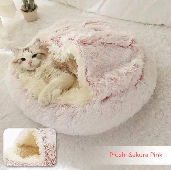 Round plush pet bed with pink shaggy hood and central cave opening