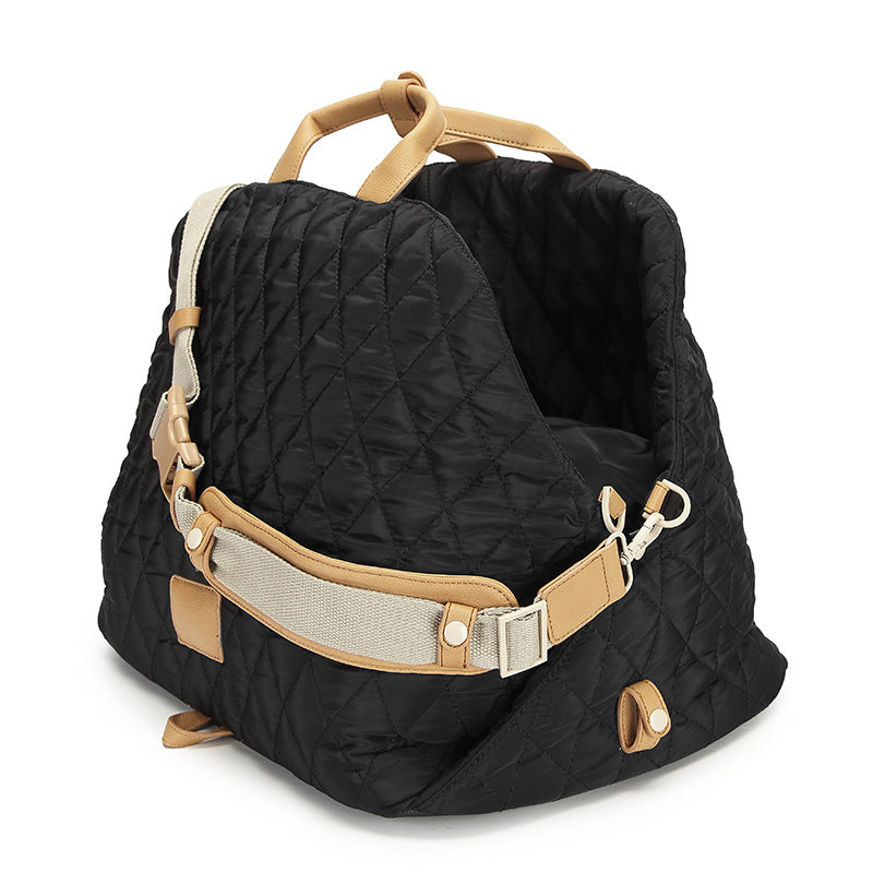 Quilted black pet handbag with tan handle, side straps, and front carry flap
