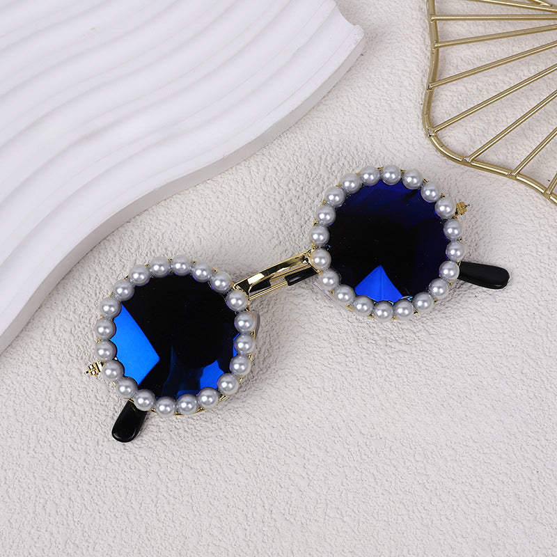 Round pearl sunglasses accessory with dark blue lenses and black arms