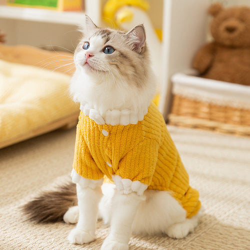 Cat standing wearing a yellow ribbed fleece pet jumpsuit with fluffy white cuff trim