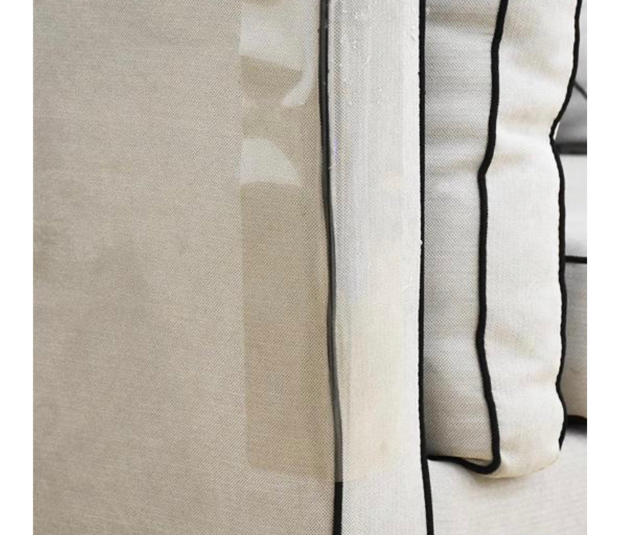 Close-up of beige cat scratching guard fabric with black trim and stitched edge