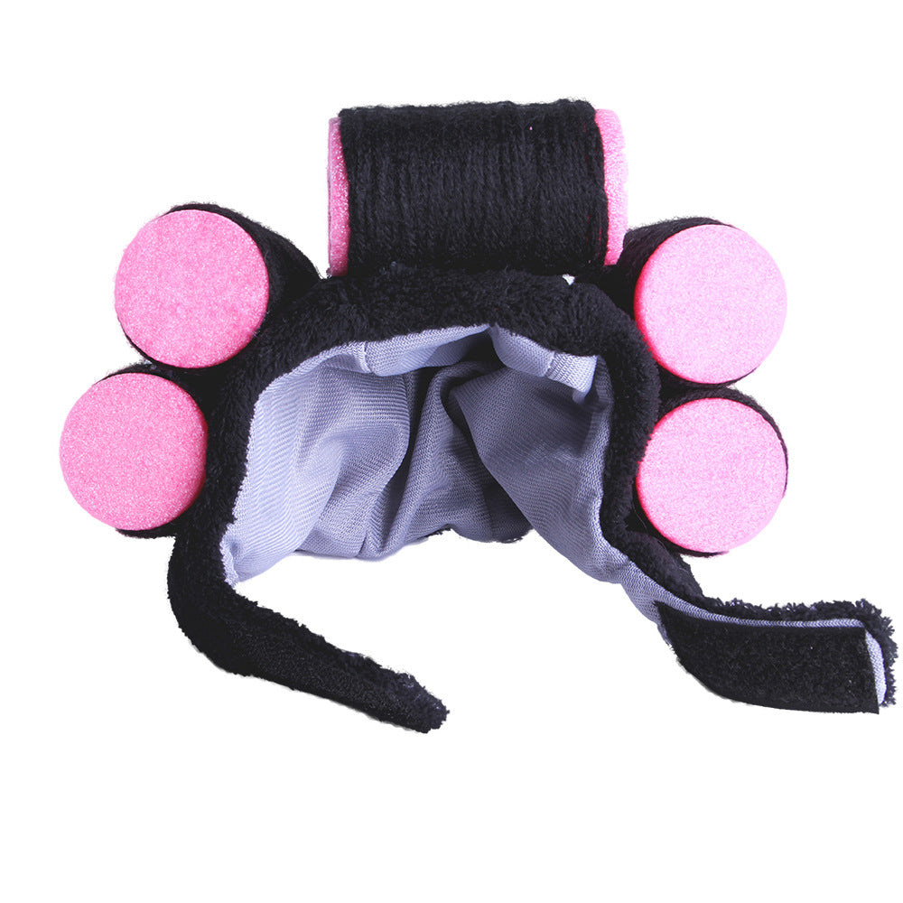 Black pet hat with pink pom-poms and blue inner fabric, side view with ear openings