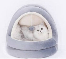 Light gray cat cave bed with cream interior cushion and hanging plush ball