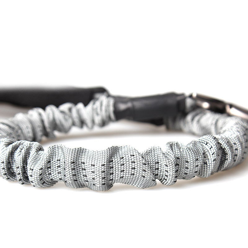 Gray bungee rope leash with stitched ridges and black connector, close-up