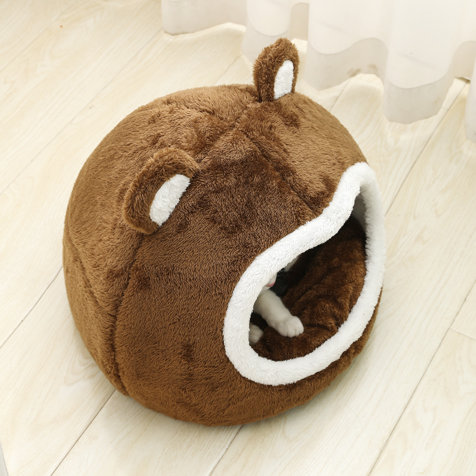 Side view of brown plush bear cat bed with white trim oval opening