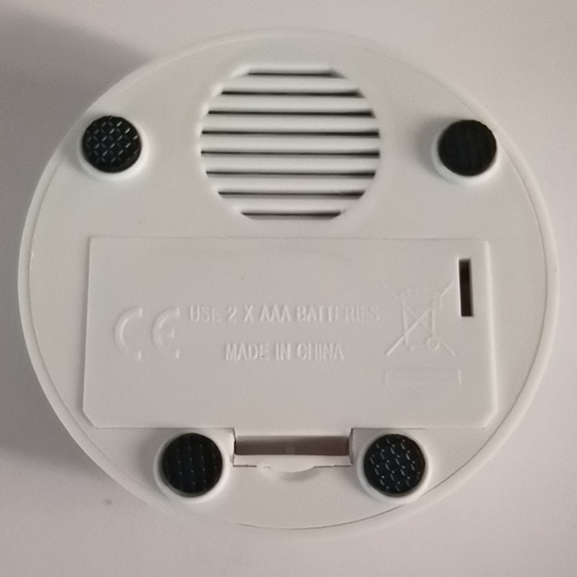 Pet button speaker sound box, white underside with speaker grille and battery door