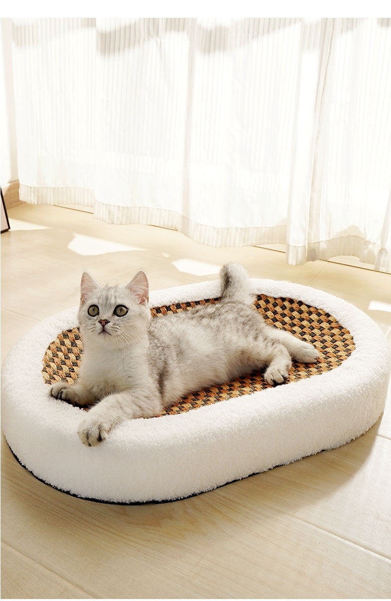 Oval cat scratch bed with white plush sides and woven sisal center, cat resting