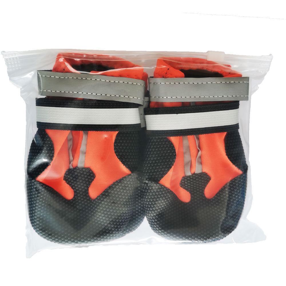 Pair of orange and black dog boots packaged in a clear bag with reflective strap