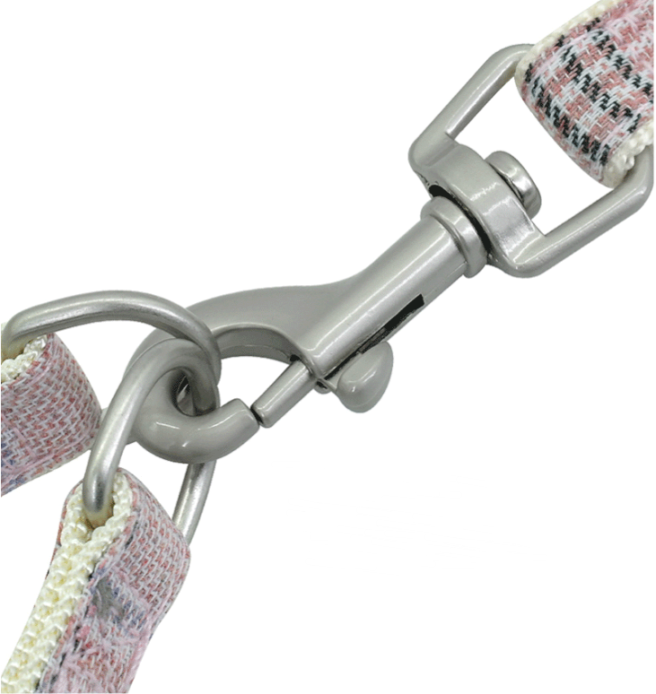 Metal dog leash clasp and D-ring with plaid webbing on a padded strap.