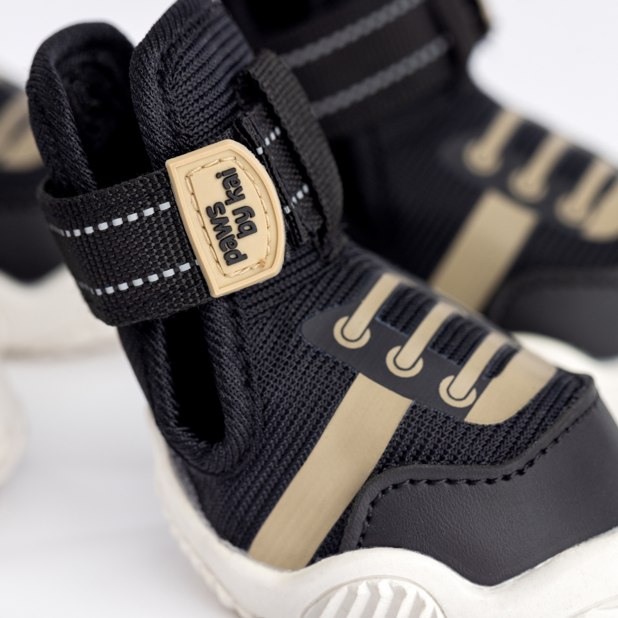 Kai- Dog sneaker detail: black fabric strap with “kai-” logo patch