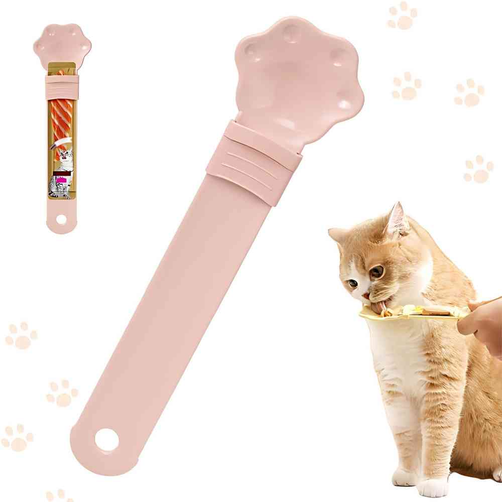 Cat treat squeeze spoon in pink with paw-shaped dispensing tip and comfort grip handle