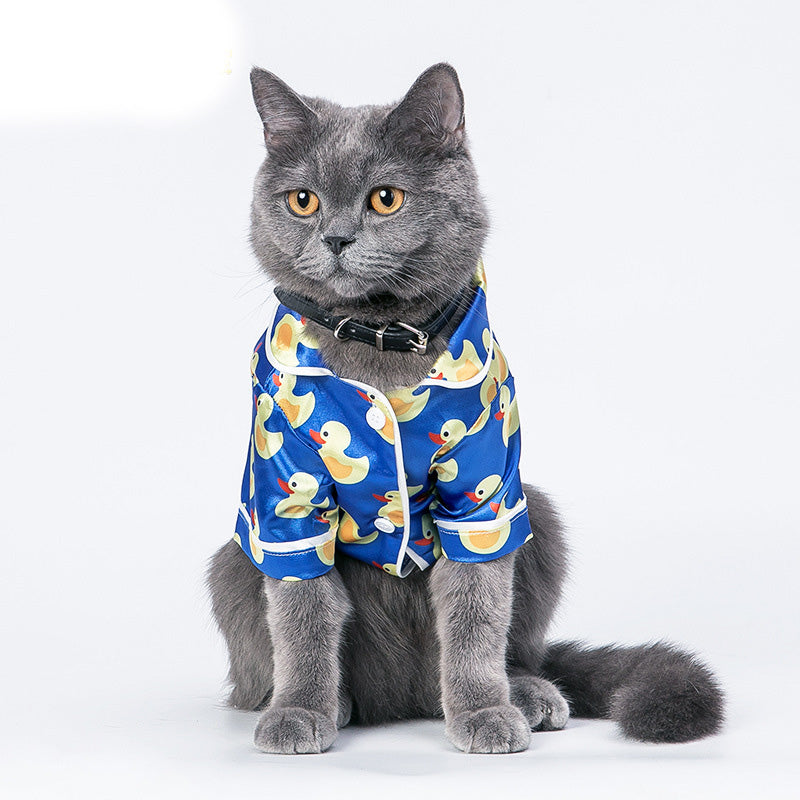 Cat wearing blue duck-print pet jacket with short sleeves and button front