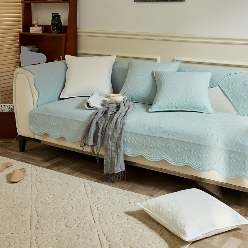 Light blue waterproof sofa cover with scalloped trim over seat and armrests