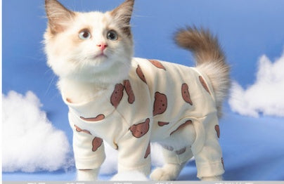Cat wearing off-white four-legged onesie with brown paw print pattern