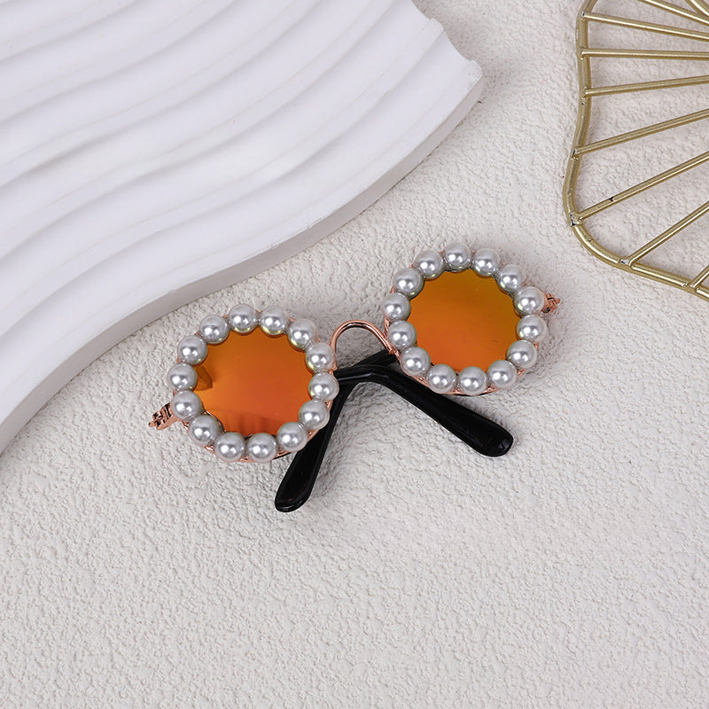 Round pearl sunglasses accessory with orange lenses and black arms