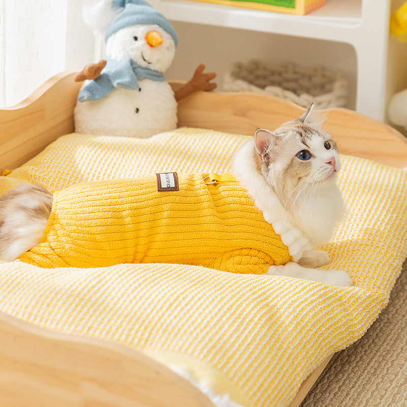 Cat resting in a yellow ribbed fleece pet jumpsuit with white ruffle collar
