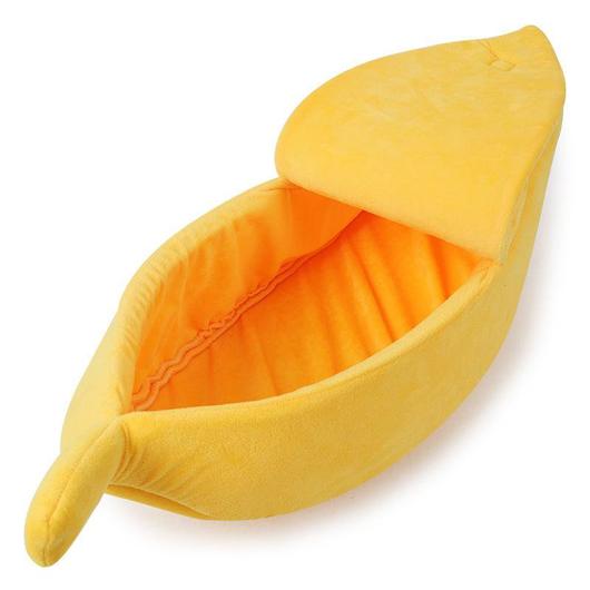 Yellow banana-shaped pet bed with orange-lined interior, plush cushion