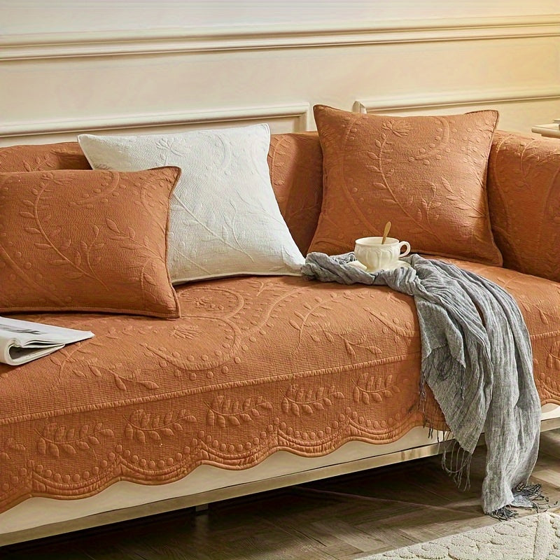 Terracotta sofa cover with textured fabric and scalloped edge, protecting the seat