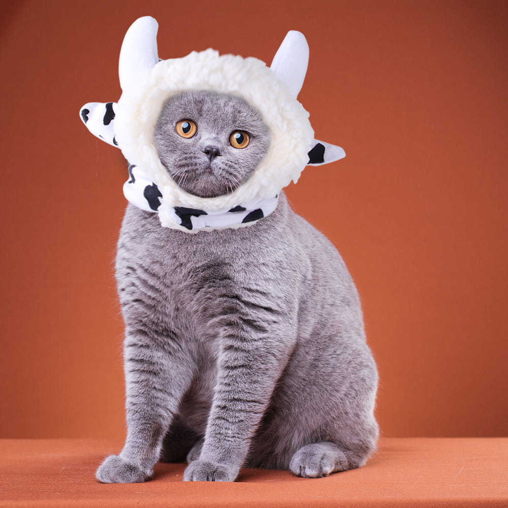 White animal hood hat with black spots and two horn-like ears