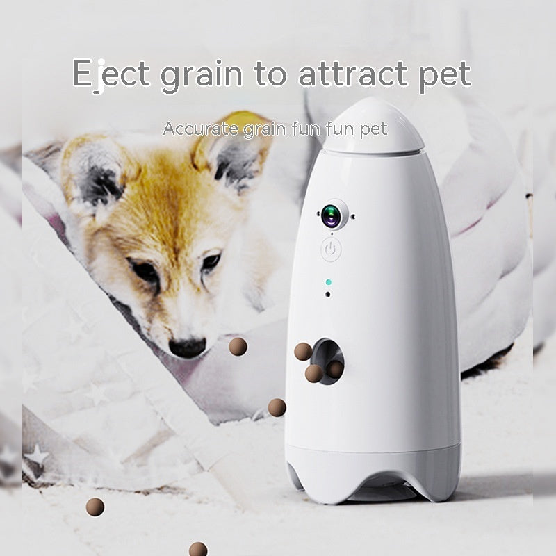 White smart pet feeder with camera beside a dog and scattered treats