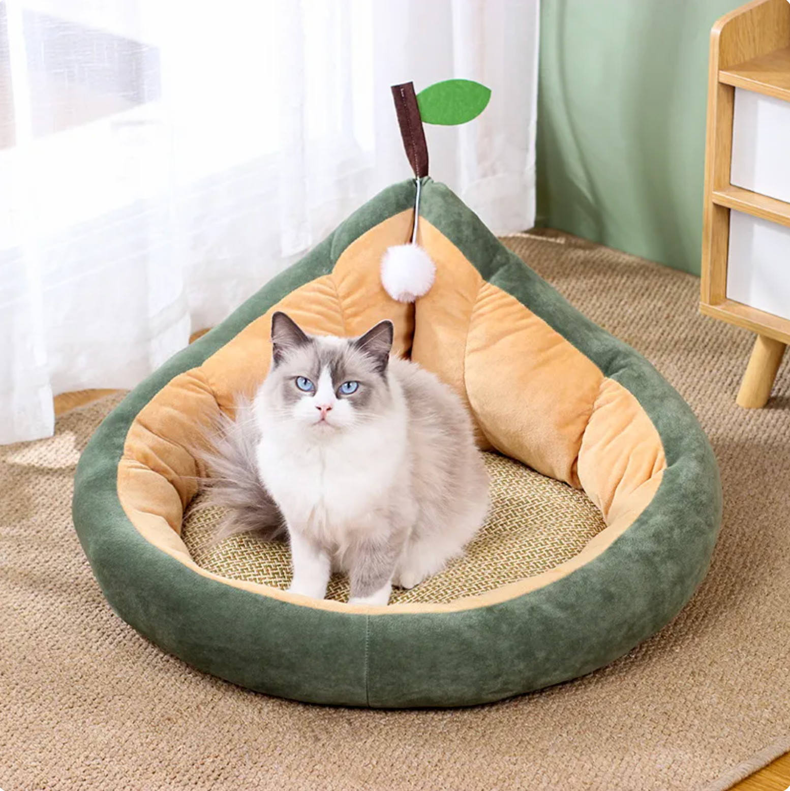Dark green pear-shaped cozy pet lounger with beige inner cushion and hanging toy