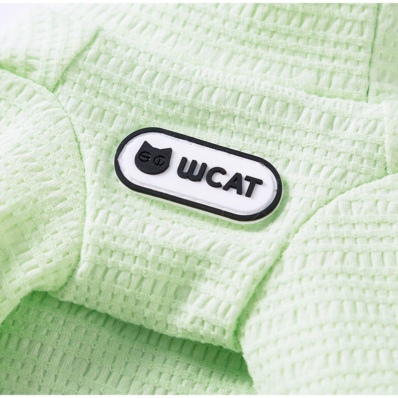 Light green knit pet shirt detail with black U C A T logo patch