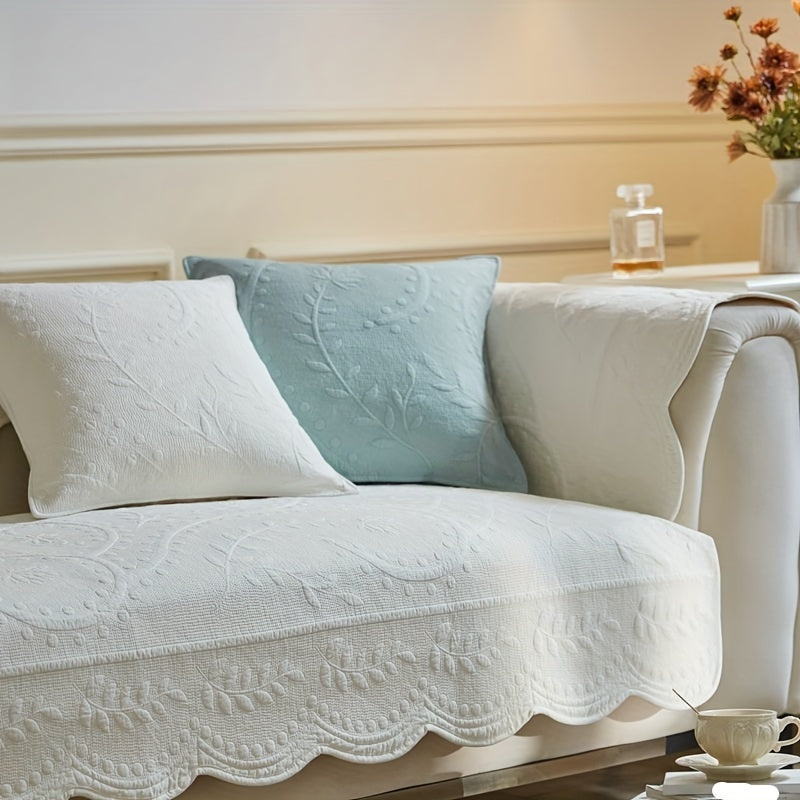 White waterproof sofa cover with scalloped hem and embossed quilt texture on seat