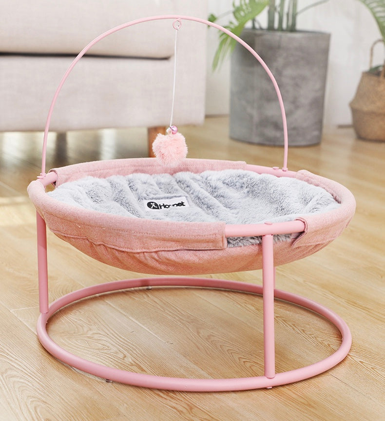 Pets bed with pink frame and round base; grey plush inner cushion and dangling toy