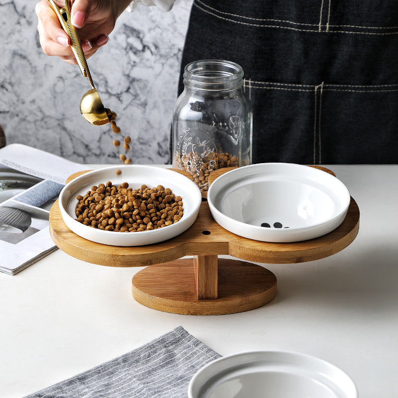 Ceramic cat bowl set with two white bowls on a round wooden stand.
