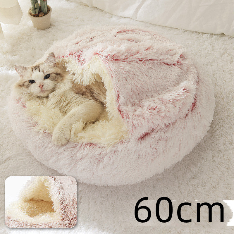 Cream round plush pet bed with pink fringe rim and cozy inner nest for cats and dogs.