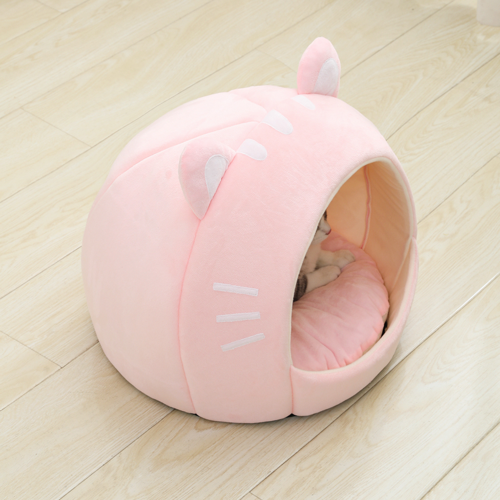 Pink cat-shaped plush pet bed house, side view with open entrance and resting cat