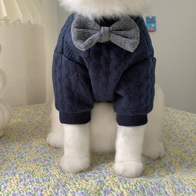 Navy pet sweater with gray bow at back, showing full legs on a white cat