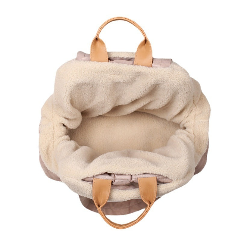 Beige plush-lined pet carrier bag with tan handles and open top