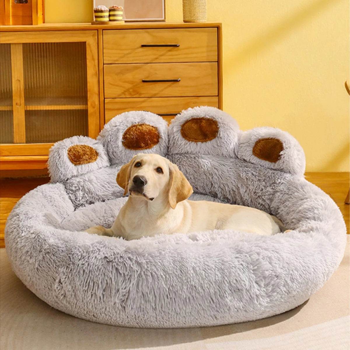 Light grey plush pet sofa bed with raised paw bolsters and round cuddle base
