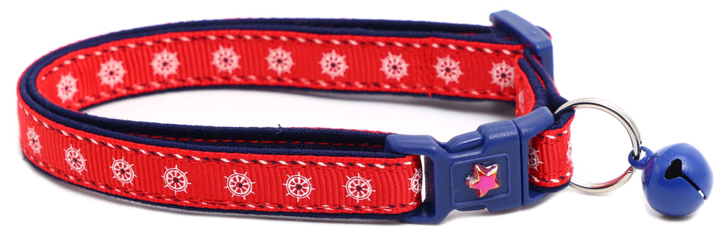 Red ships wheel breakaway cat collar with navy trim; blue jingle bell and star badge buckle.