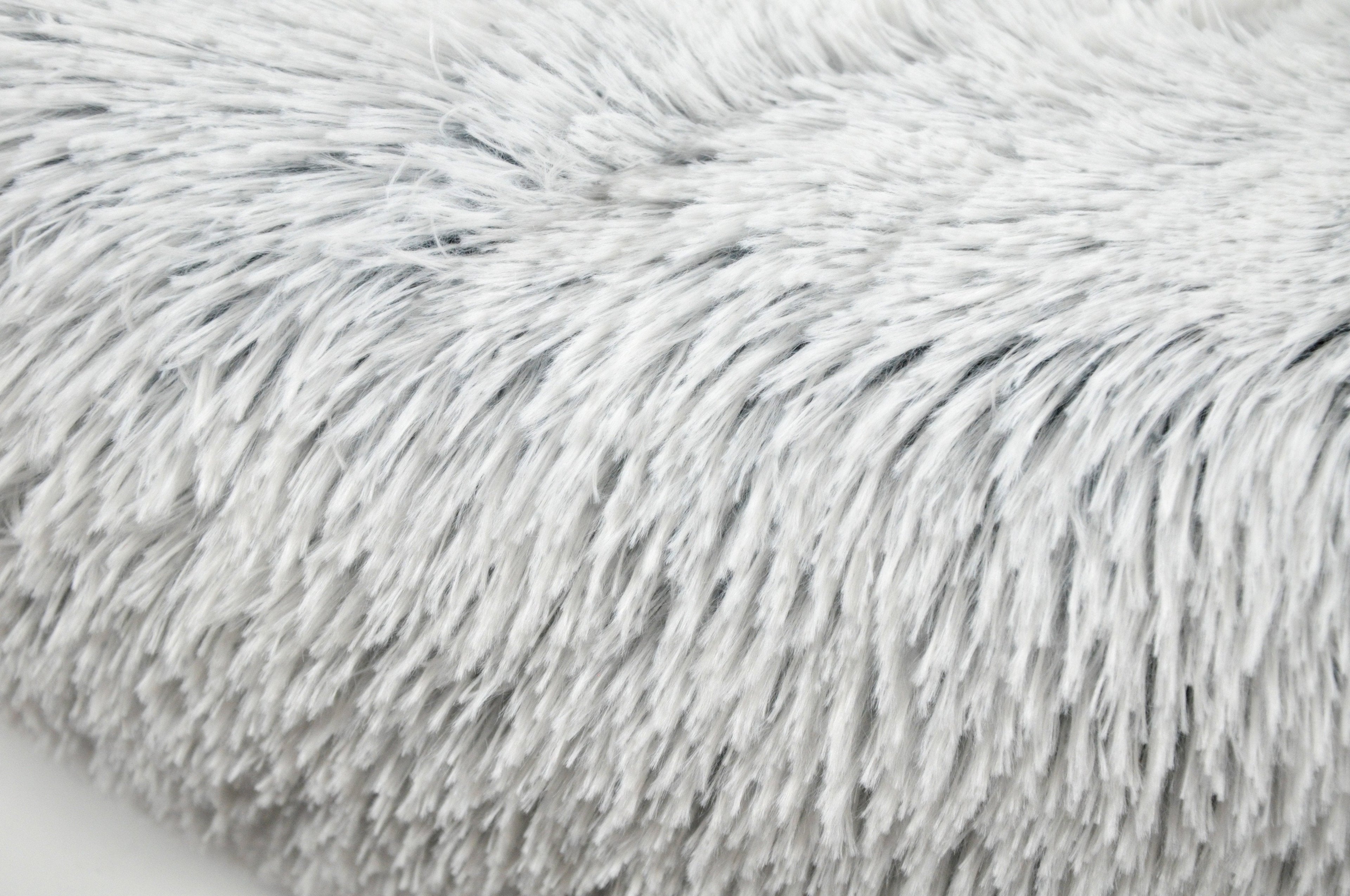 Light gray shag faux-fur pet bed surface with dense, long-pile texture