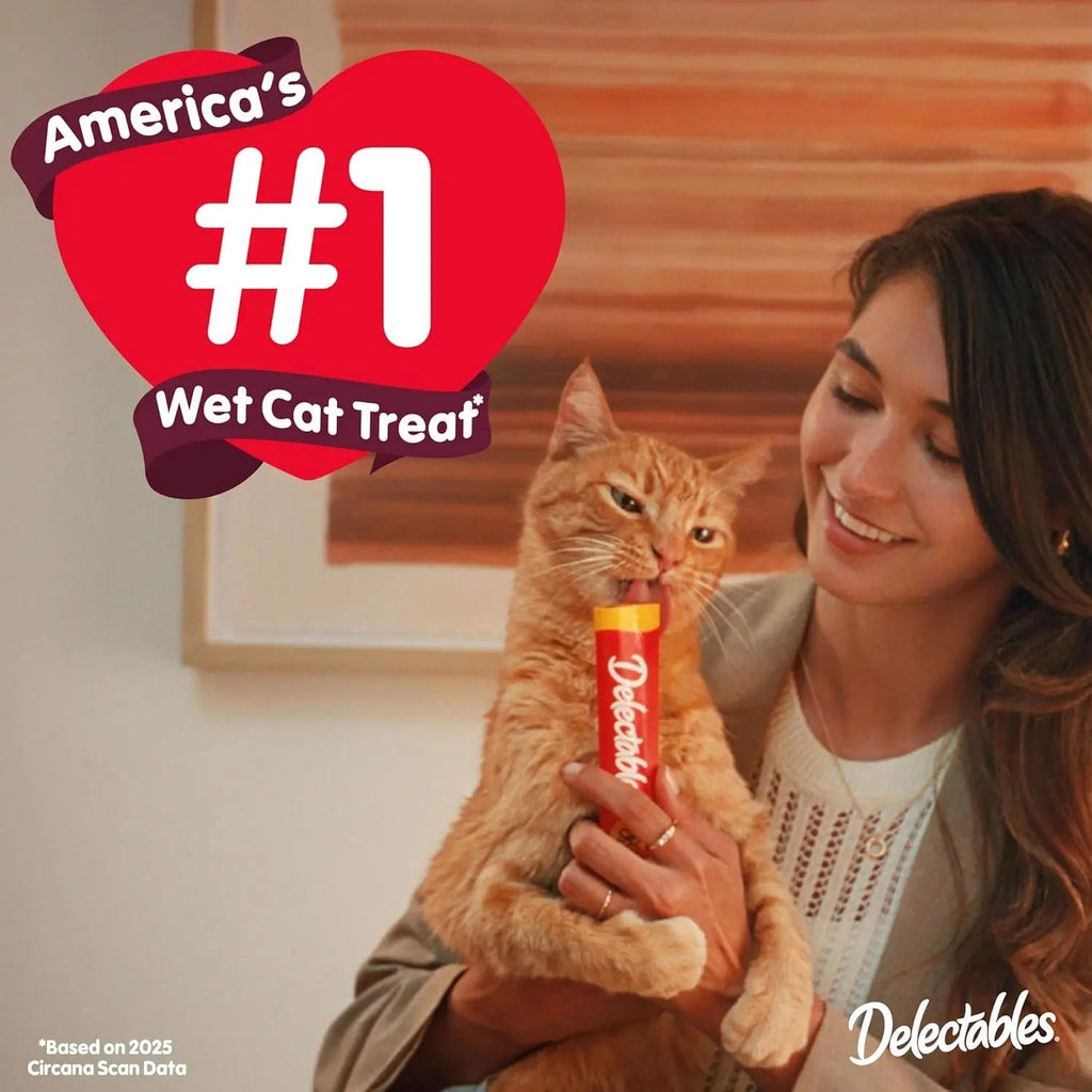 Cat squeeze-up treat tube held in hand for wet cat treat promotion