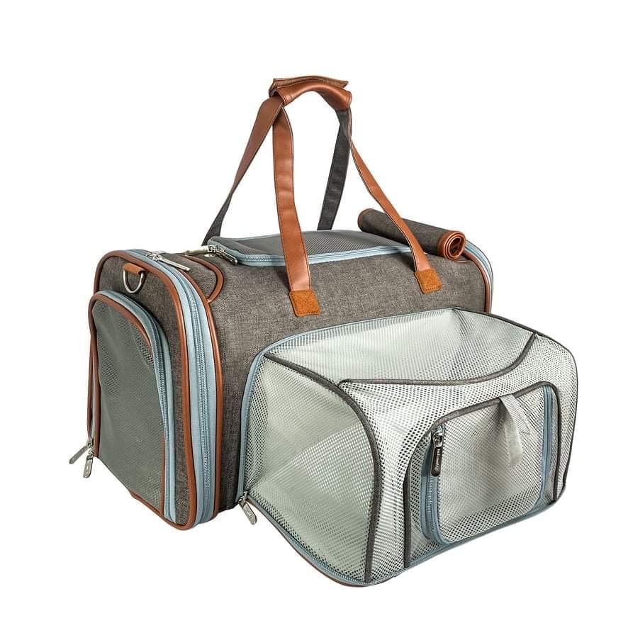 Gray mini pet carrier with expandable front mesh, brown handles and rolled accessory strap