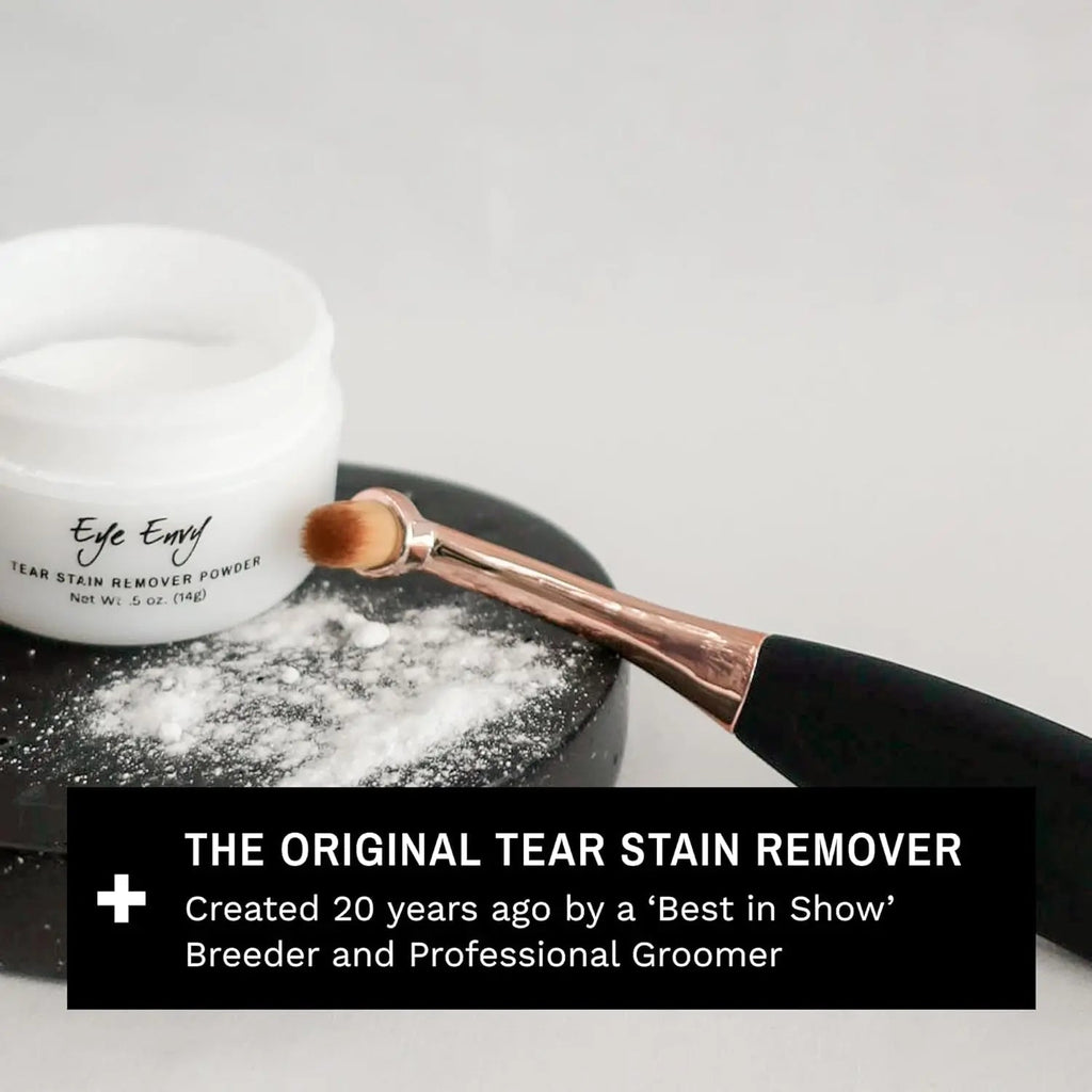 Application brush dusted with tear stain remover powder next to powder jar