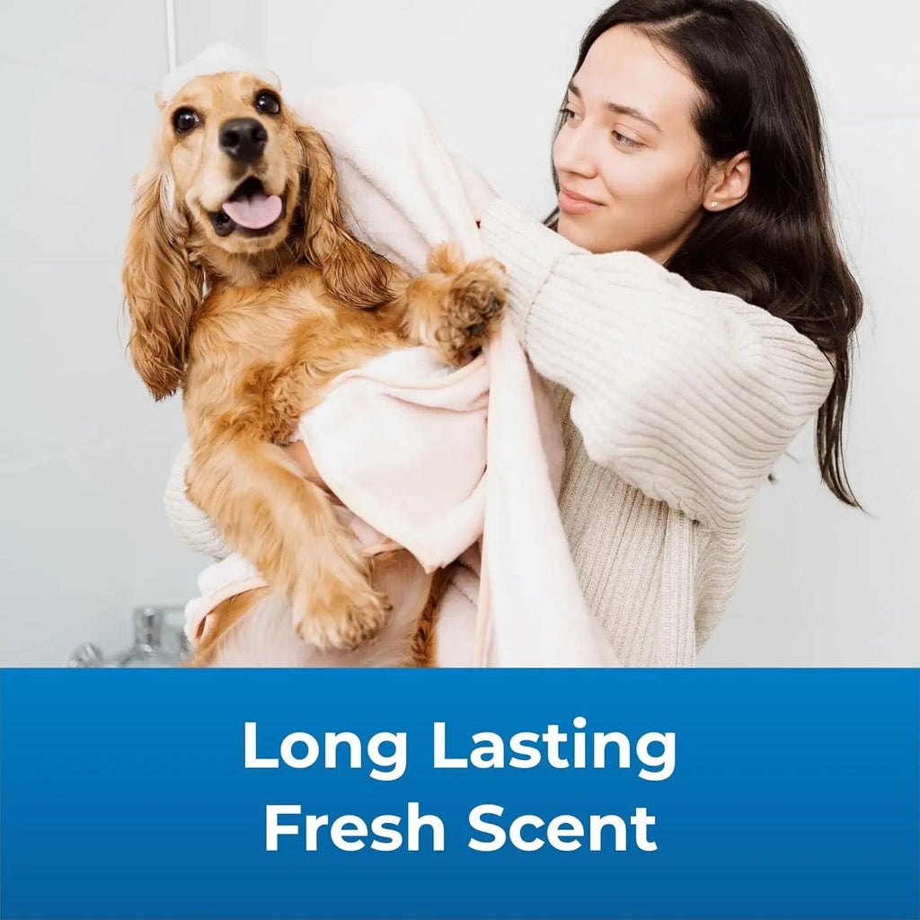 Dog shampoo and conditioner set, woman holding a tan dog wrapped in a towel